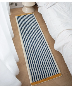 Detailed top view of a long plush rug with blue stripes and yellow borders on a wooden floor