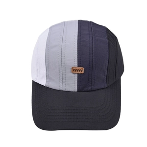 Detail of multi-color paneled baseball cap featuring a premium brown leather logo patch