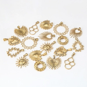 Golden stainless steel charms in sun and heart shapes for jewelry making on white background