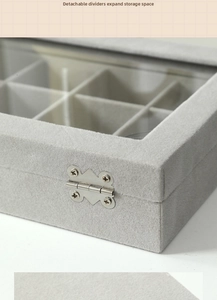 Detail of grey velvet jewelry box with removable dividers and metal hinges for rings
