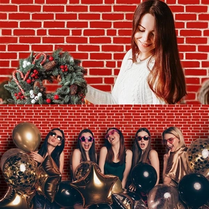 Close-up of festive Christmas wreath and golden party balloons against red brick background