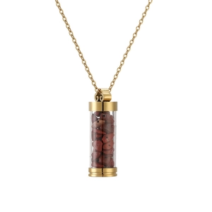 Close-up of golden cylinder perfume bottle pendant with red jasper stones on a chain