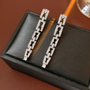 Détail de boucles d'oreilles pendantes en argent serties de zircons sur support