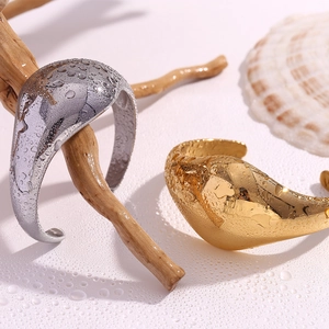 Detail of minimalist 18K gold and silver plated chunky bangles with water droplets