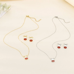 Detailed view of gold and silver Christmas reindeer jewelry sets with enamel pendants