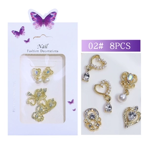 Macro detail of tulip and rabbit themed gold alloy nail charms with pearls and crystals