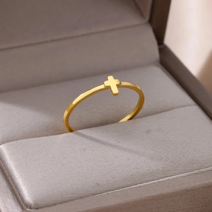 Detail shot of a minimalist gold-plated stainless steel ring with a small cross symbol