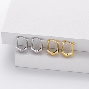 Close-up of S925 sterling silver geometric hoop earrings on a white display base