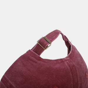 Detailed macro view of the vintage wine red washed cotton baseball cap with adjustable metal buckle