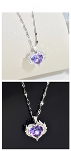 Detail view of purple heart crystal pendant with silver wings on dual texture background