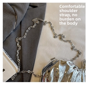 Detail of silver fluid-shaped mirror handbag with slim metallic chain strap