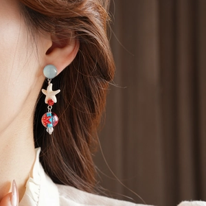 Detail of beach style starfish earrings with lampwork glass beads and light blue studs