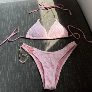 Sexy light pink bikini set with textured fabric and elegant gold chain link straps