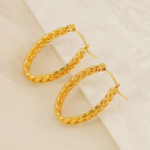 Detailed macro view of 18K gold plated stainless steel earrings with braided texture