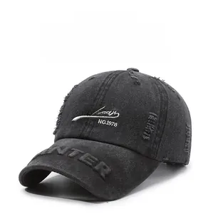Detailed view of distressed dark grey baseball cap with embroidery and ripped denim texture