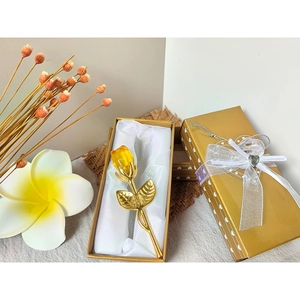 Detailed view of amber crystal rose with golden stem in a premium gold gift box
