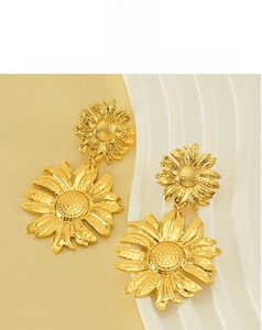 Close-up of golden sunflower earrings featuring intricate petal texture and vintage style