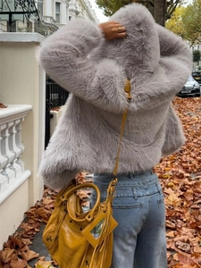Back view of a faux fur hooded jacket in light purple with a yellow tote bag