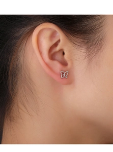 Close-up of minimalist s925 silver butterfly stud earring worn on a model's ear lobe
