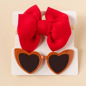 Detail of red bow nylon headband and heart-shaped sunglasses on white display card