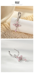Detailed view of silver cross earrings featuring pink pear-cut and round zircon stones