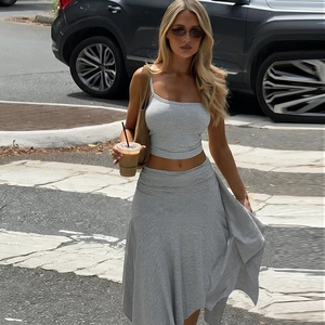 Grey two-piece set featuring off-shoulder crop top and ruffled skirt on a city street