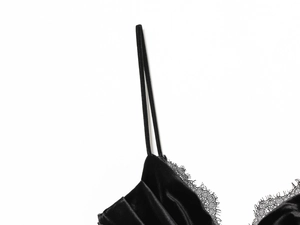 Detailaufnahme des schwarzen Samtkleids mit Wimpernspitze und schmalen Trägern