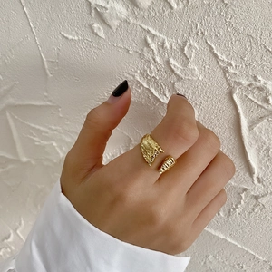 Macro detail of gold adjustable open ring with minimalist molten lava texture finish