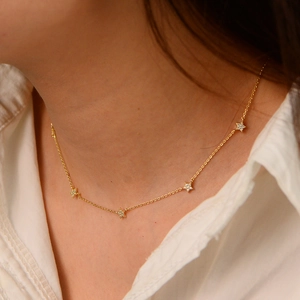 Macro view of five dainty gold-plated star pendants with sparkling zircons on a fine chain