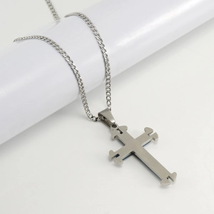 Macro detail of silver stainless steel cross pendant and durable chain links on white stand