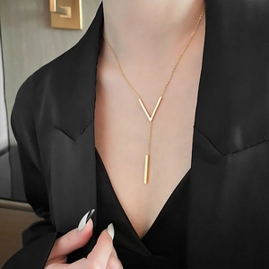 Elegant gold titanium steel necklace with V-shaped pendant on black suit background