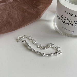 Macro view of woven S925 sterling silver geometric bracelet with metallic luster