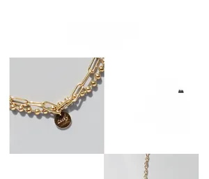 Détail du bracelet double couche doré avec gravure lucky et maillons trombone
