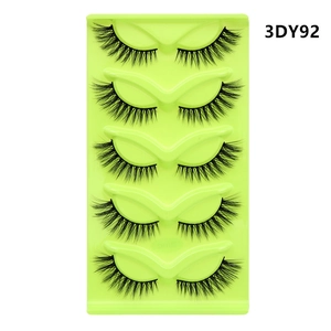 Detailed view of 5 pairs of black fox-eye cat-eye false eyelashes on a green tray