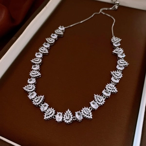 Detailed view of vintage silver floral necklace with crystals in a brown jewelry box