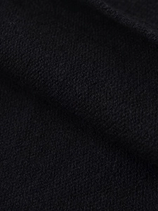 Macro shot of black textured knit fabric showing wool fiber detail on the puff sleeve top