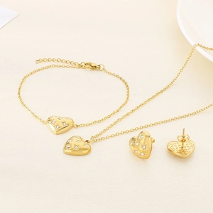 Flat lay of gold heart jewelry set featuring sparkling stones on necklace and earrings