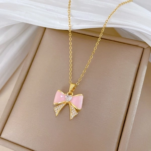 Detailed shot of pink enamel bow necklace with sparkling crystals in a jewelry box