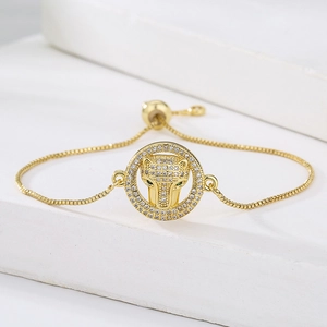 Gold plated leopard head bracelet with white zircons and green gem eyes on stone base