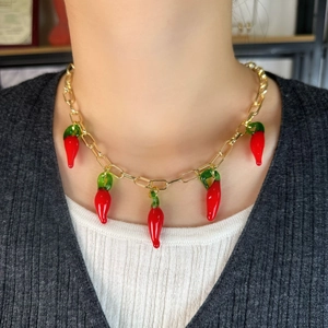 Detail view of gold link necklace with five red lampwork glass chili pepper pendants