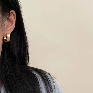 Minimalist brushed gold thick hoop earrings for women shown on model profile view