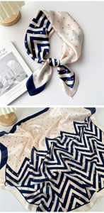 Detail of navy blue wavy pattern and pink polka dots on a silky neck scarf