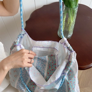 Internal view of floral canvas tote bag featuring small open pocket and drawstring closure