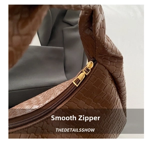 Detail of premium gold zipper and brown woven texture on casual shoulder bag