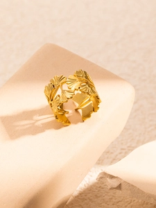 Detailed view of adjustable golden ginkgo leaf ring with textured metal veins on stone