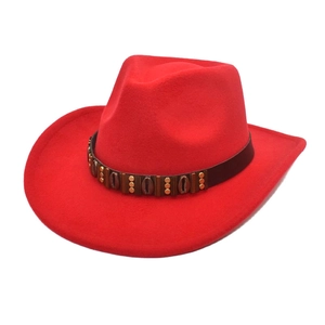 Detail of red cowboy hat with leather band and golden rivets on polished wool felt