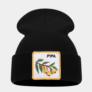 Close-up of black knitted beanie featuring embroidered fruit patch with PIPA text detail