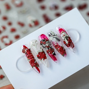 Unghie finte stiletto gotiche 3D con rose rosse e disegni di scheletri