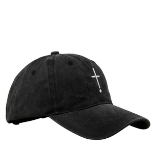 Close-up of cross embroidery and washed cotton fabric texture on a black baseball cap
