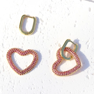 Orecchini a cuore placcati oro 18K con zirconia rosa su sfondo bianco testurizzato